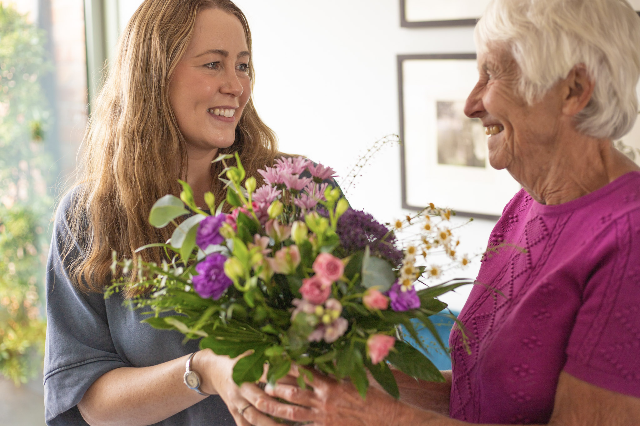 Granddaughter presenting same day delivery flowers to grandmother